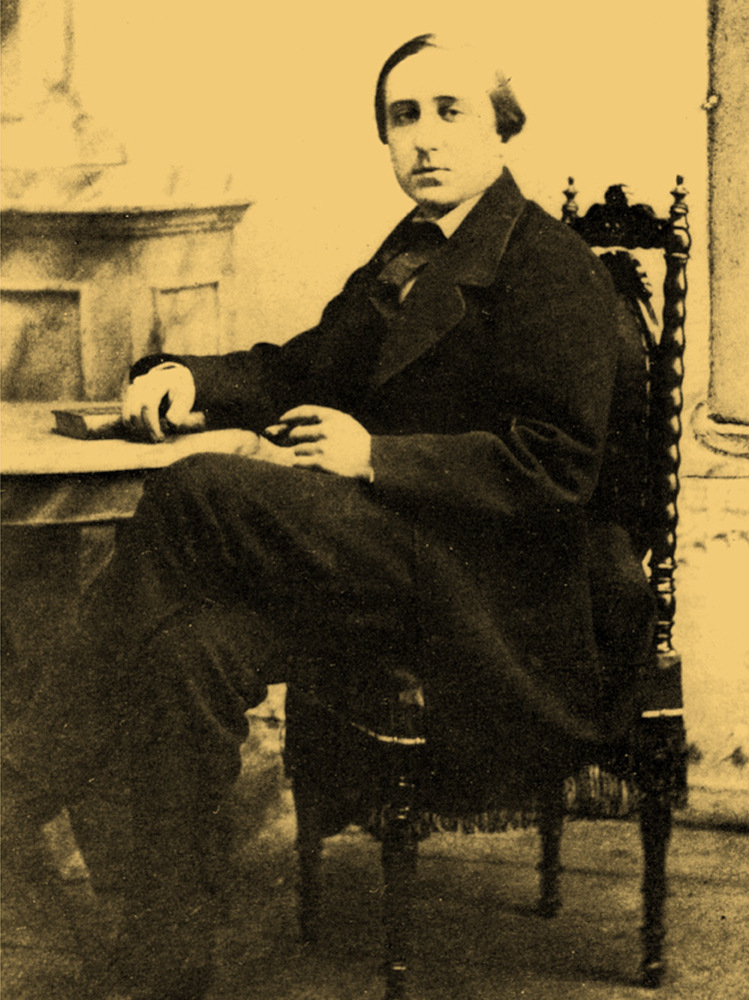 Omslag till del 1 ”1839–1872: Liberalt uppvaknande – unga år”: Leo Mechelin fotograferad 1861 eller 1862. Mechelin sitter vid ett bord med högra handen vilande på en bok.